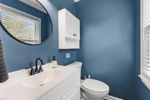 a blue bathroom with a toilet and a mirror at Summerville’s Tea House in Summerville +11 photos