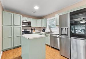 a kitchen with white cabinets and stainless steel appliances at Summerville’s Tea House in Summerville