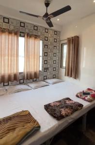 a bedroom with a large bed with a ceiling fan at HOTEL IN UJJAIn in Ujjain