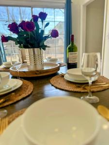 a table with plates and a bottle of wine and flowers at Summerville’s Charm House in Summerville +19 photos