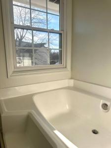 a white bath tub in a bathroom with a window at Summerville’s Charm House in Summerville