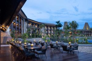 a hotel patio with tables and chairs at night at Myze Hotel Waingapu in Waingapu