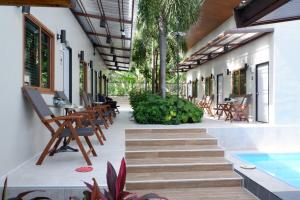 a patio with wooden chairs and a swimming pool at Villa nabon in Ban Suan