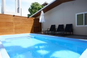 a swimming pool with a wooden fence and chairs at Villa nabon in Ban Suan +2 photos