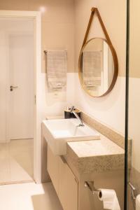 a bathroom with a sink and a mirror at Edifício Catamara in Vila Velha +7 photos