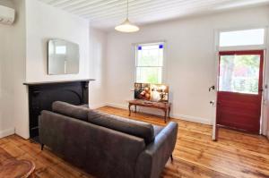 a living room with a couch and a fireplace at A Warm & Charming Retreat in Castlemaine