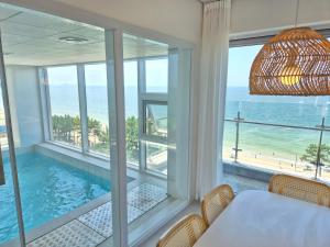 a dining room with a view of the ocean at 대천 아이오션 풀빌라 호텔 in Koryŏng