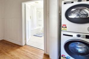a washer and dryer in a room with a doorway at A Warm & Charming Retreat in Castlemaine
