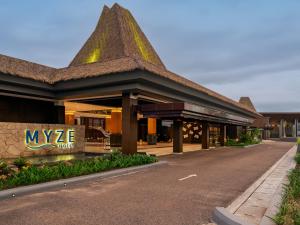 a building with a sign on the side of a road at Myze Hotel Waingapu in Waingapu