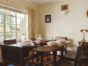 a dining room with a table with plates and wine glasses at Coachmans Close in Milverton