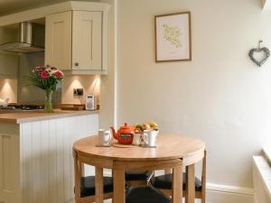a small table in a kitchen with a bowl of fruit on it at Rooftops - Uk34065 in Grassington