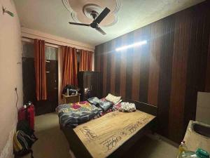 a bedroom with a bed and a ceiling fan at Sweet bnb in Greater Noida