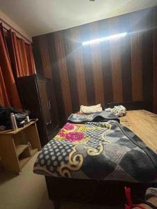 a bedroom with a bed with a wooden wall at Sweet bnb in Greater Noida