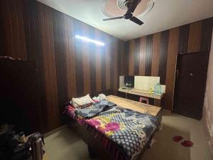 a bedroom with a bed with a ceiling fan at Sweet bnb in Greater Noida
