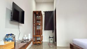 a living room with a television on a wall at Villa Bumi Detani in Selabintana