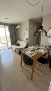 a dining room with a table and chairs and a bed at Ap Mirante Fortaleza 5min da Praia com Piscina e Rooftop para 6 pessoas in Fortaleza