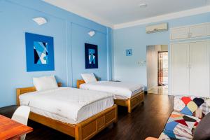 two beds in a room with blue walls at Ananas Beach Hotel in Vung Tau