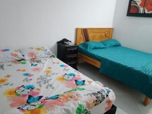 a bedroom with two beds and a night stand with a bedskirts at WalApar in San Rafael