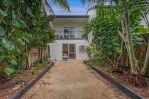 a house with a fence and palm trees at PET FRIENDLY Coolview in Cannonvale