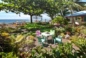 einen Tisch und Stühle mit Meerblick im Hintergrund in der Unterkunft Kurma Eco Beach Lodge in Mambajao