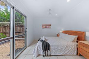 a bedroom with a bed and a large window at PET FRIENDLY Coolview in Cannonvale