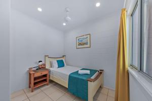a small bedroom with a bed and a window at PET FRIENDLY Coolview in Cannonvale