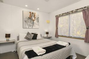 a bedroom with a bed and a zebra picture on the wall at Howlong Caravan Park in Howlong +17 photos