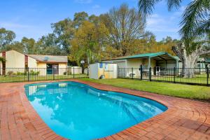 a swimming pool in a yard with a house at Howlong Caravan Park in Howlong