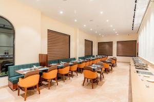 a row of tables and chairs in a restaurant at Playotel Premier, Ujjain in Ujjain