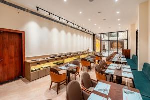a restaurant with tables and chairs in a room at Playotel Premier, Ujjain in Ujjain
