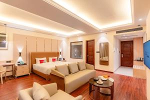 a hotel room with a bed and a couch at Playotel Premier, Ujjain in Ujjain