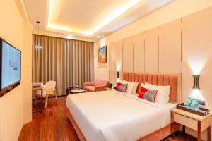a hotel room with a bed and a flat screen tv at Playotel Premier, Ujjain in Ujjain +54 photos