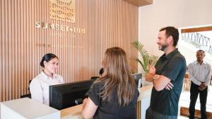 a group of people standing around a reception desk at Sunset INN by Pro-Ema in Dili