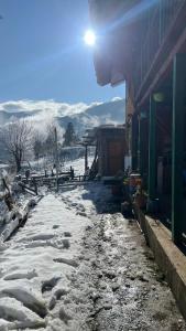 ein schneebedeckter Gehweg neben einem Gebäude in der Unterkunft DADU'S Cafe in Sainj + 16 Fotos