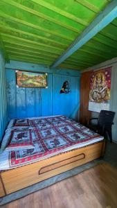 ein Schlafzimmer mit einem großen Bett und blauen Wänden in der Unterkunft DADU'S Cafe in Sainj