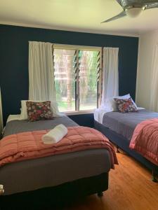 a bedroom with two beds and a window at Sea Turtle Lodge and Villas in Rarotonga