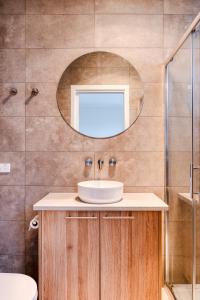 a bathroom with a sink and a mirror at Sixty - House 1 in Currie +11 photos