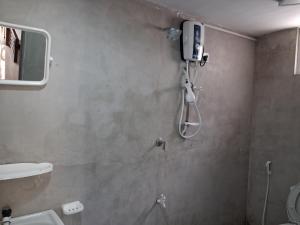 a shower in a bathroom with a mirror at Beach cabin uppuveli in Trincomalee