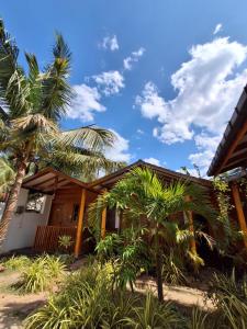 a house with palm trees in front of it at Beach cabin uppuveli in Trincomalee