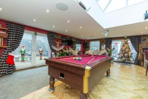 a pool table in a living room with a christmas tree at Waterside Equestrian Lodge in Durham