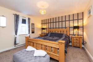 a bedroom with a large wooden bed and a table at Waterside Equestrian Lodge in Durham