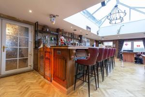 a bar with red bar stools in a room at Waterside Equestrian Lodge in Durham