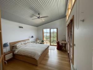 a bedroom with a large bed with a ceiling at Cedar Hill Retreat in Venus Bay
