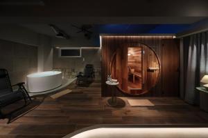 a bathroom with a tub and a round mirror at クリスタルサウナ in Miyako-jima