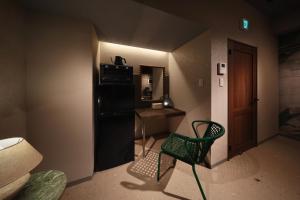 a room with a chair and a desk and a door at クリスタルサウナ in Miyako-jima