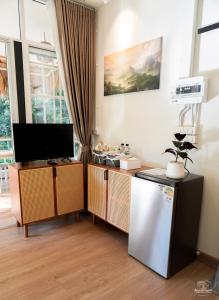 a living room with a television and a refrigerator at Nuearnaam Lychee House Chiang Mai in Ban Pa Miang