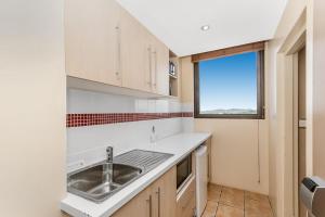 a kitchen with a sink and a window at Aquarius On The Beach in Townsville