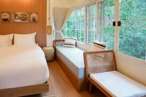 a bedroom with two beds and a window at Nuearnaam Lychee House Chiang Mai in Ban Pa Miang