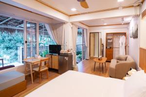 a bedroom with a bed and a living room at Nuearnaam Lychee House Chiang Mai in Ban Pa Miang