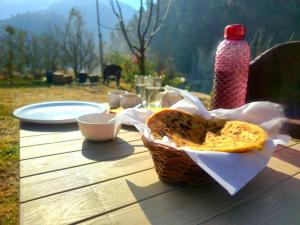 a basket of bread sitting on a picnic table at River View Sunrise Cottages Tirthan Valley in Kulu